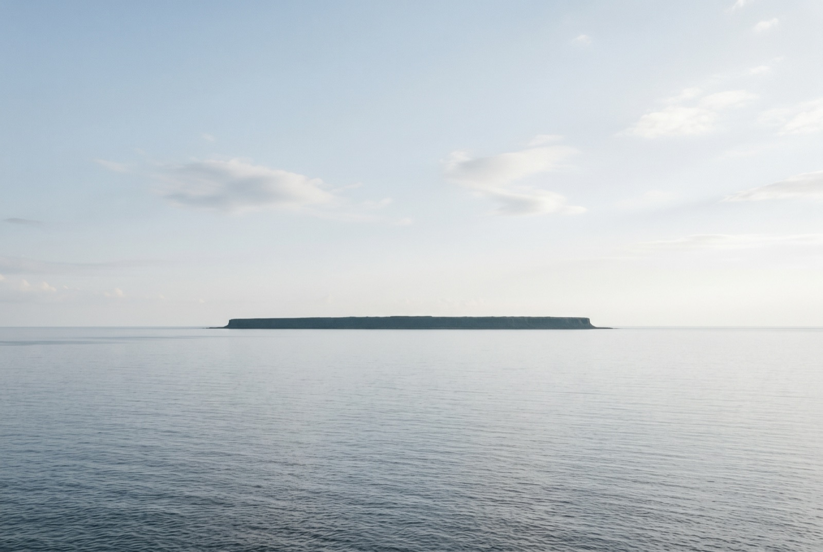 静かな海の上に浮かぶ、平らな島（イメージ画像）